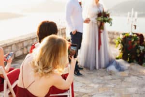 Wedding guests using their phones and taking picture of ceremony